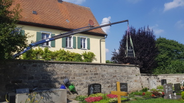 Kran im Einsatz über Friedhofsmauer Kran im Einsatz über Friedhofsmauer
